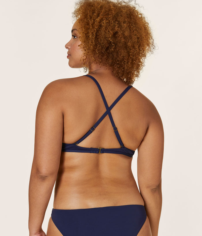 Back view of a model wearing The Valencia Top - Flat - Navy, showcasing the adjustable cross-back straps and secure back closure.