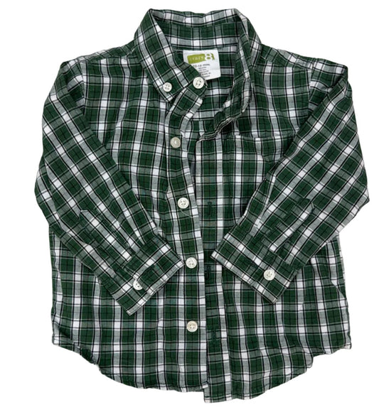 A green and white plaid long-sleeve button-down shirt laid flat on a light wood floor.