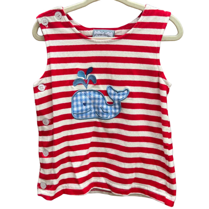 A sleeveless children's top with red and white horizontal stripes, featuring a blue and white gingham whale applique on the front. The top has snap buttons on the shoulder and side and is shown hanging on a white plastic hanger against a brick wall background.