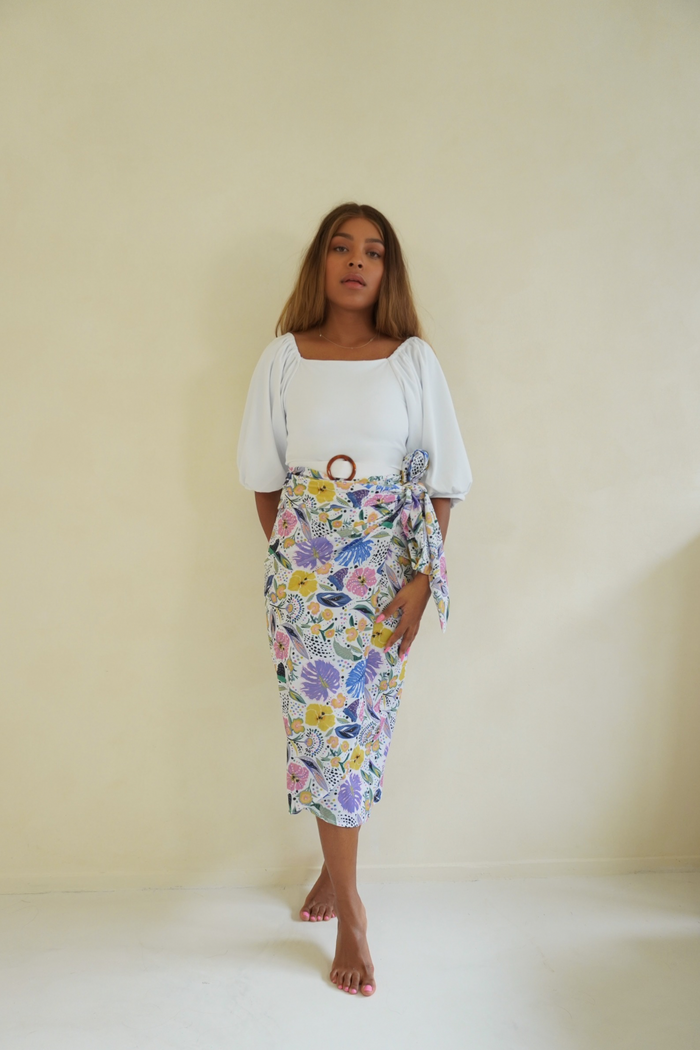 Woman ready for the beach in the Ana Swim Skirt in floral print, a modest and fashionable addition to any swimwear collection.