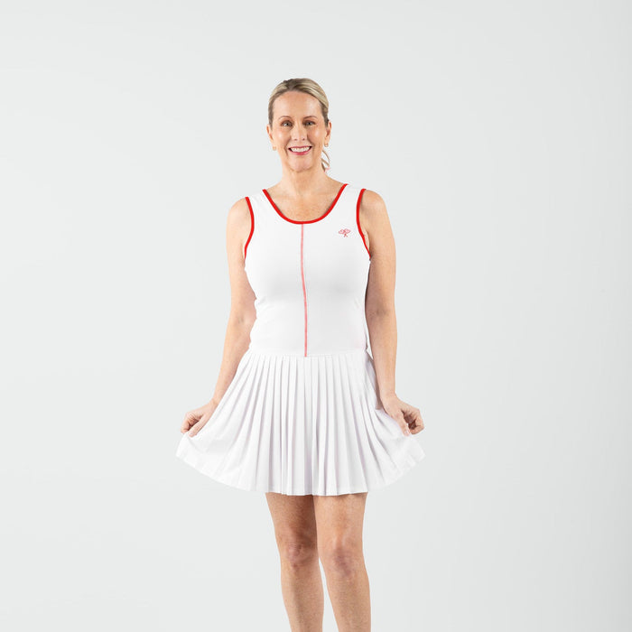 Woman wearing a white tennis dress with red accents on a white background