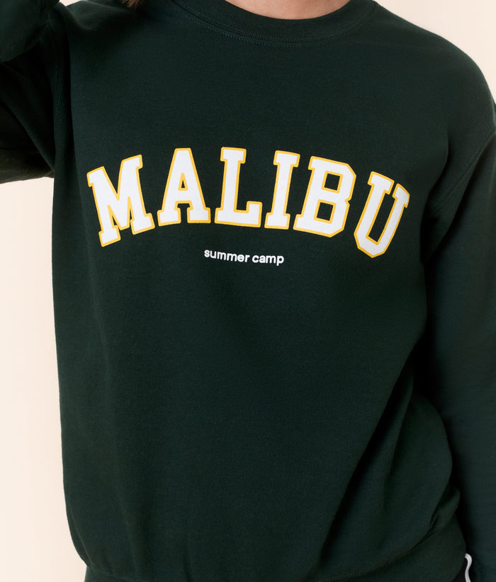 Close-up of the Mindy Sweatshirt in forest green cotton with 'Malibu summer camp' varsity lettering by Andie Swim