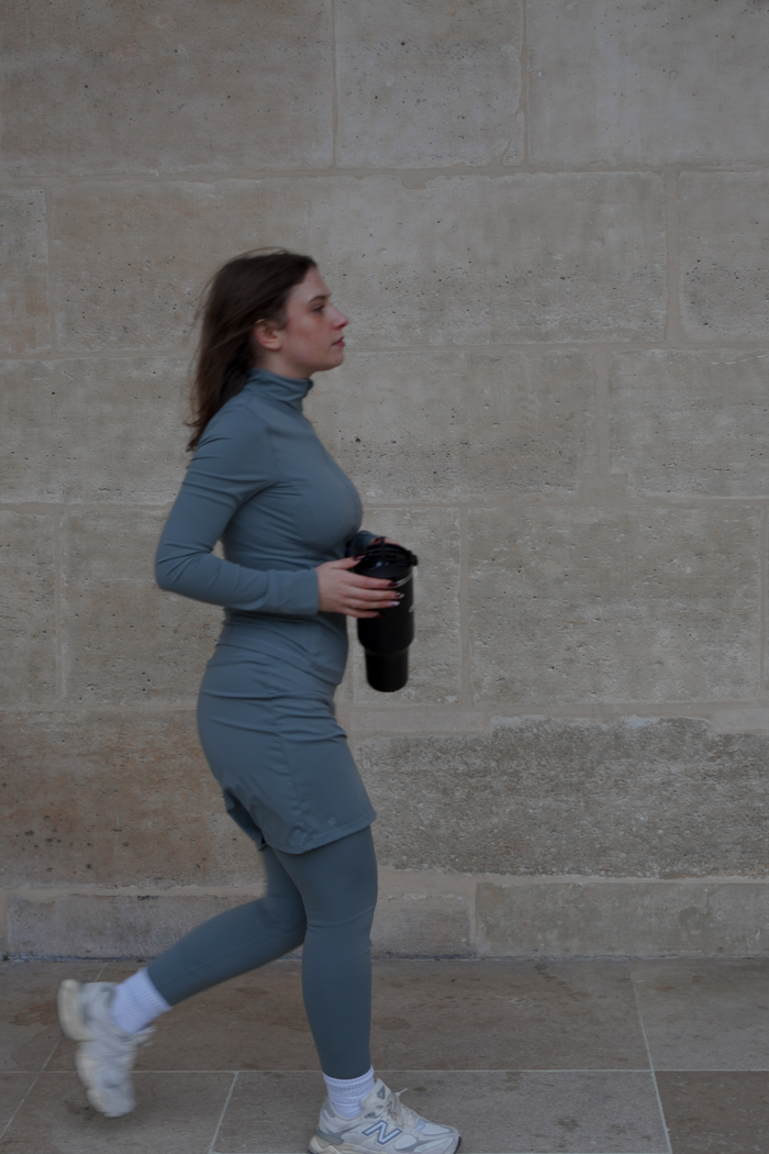 Side view of the model wearing the sage green 18-inch modest sport skirt with integrated leggings, perfect for active lifestyles.