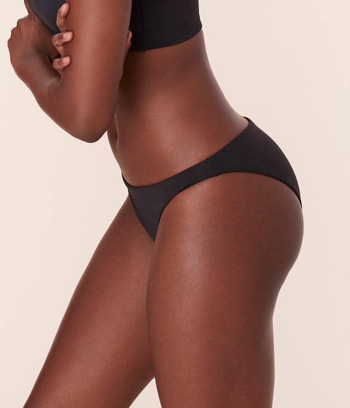 Side profile of Andie Swim Cheeky Bottom in black, featuring high leg cut and medium compression for a sleek poolside look