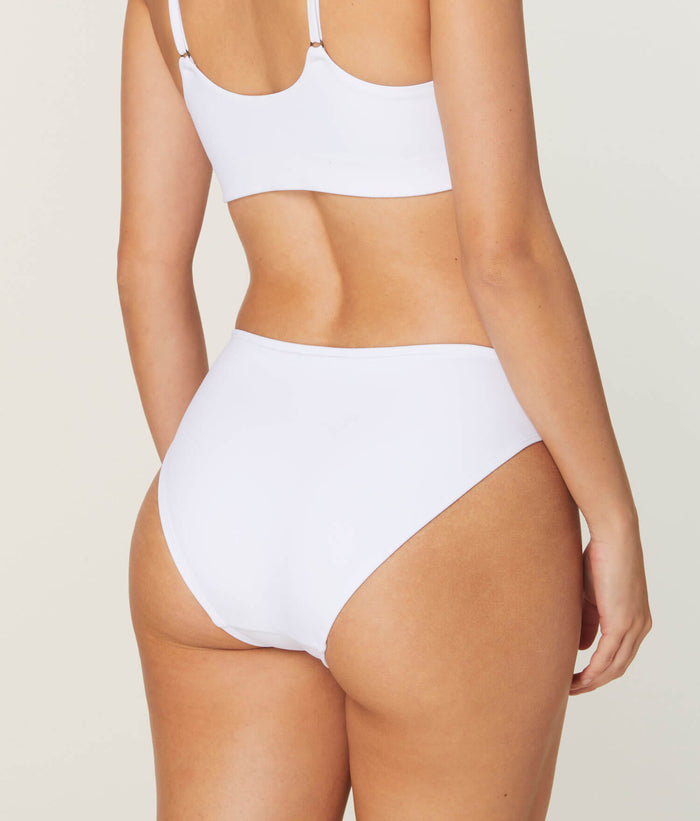 Andie Swim white bikini bottom in eco-nylon, medium seat coverage, low rise, compressive fit from back angle