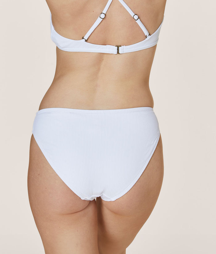 Model wearing Andie Swim eco ribbed white bikini bottom, low rise, medium seat coverage for a comfortable fit