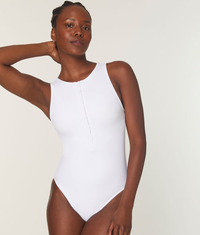 Model in The Malibu One Piece by Andie Swim in white, highlighting high snap-button neckline and compressive fabric fit