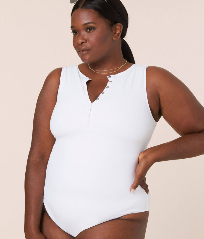 Plus-size model wearing The Malibu One Piece in white by Andie Swim, featuring a snap-front neckline and medium seat coverage.