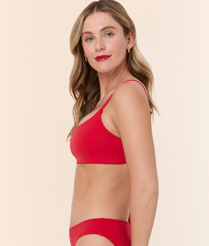 Side view of model wearing Andie Swim's Maui Bikini Top in Cherry Red, showcasing the longline design and thin adjustable straps