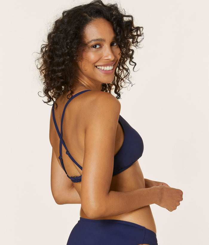 Back view of another model wearing The Valencia Top - Flat - Navy, featuring the adjustable cross-back straps and supportive band.