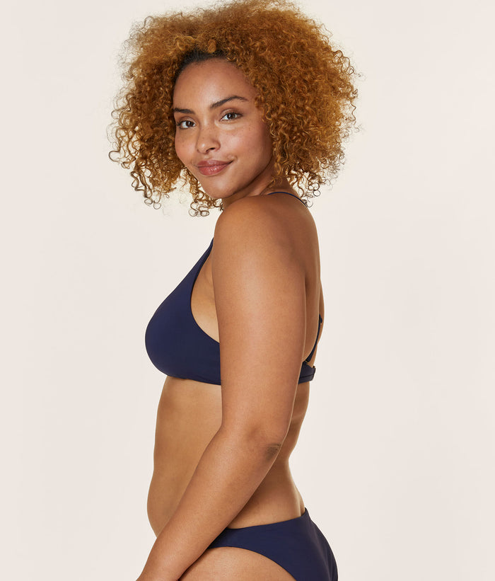 Side view of a model wearing The Valencia Top - Flat - Navy, highlighting the slight V-neckline and comfortable fit.