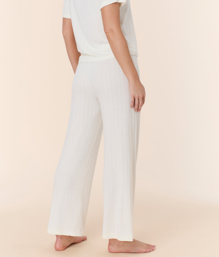 Back view of snow white wide leg pant by Andie Swim, showcasing relaxed fit and elastic waistband on model.