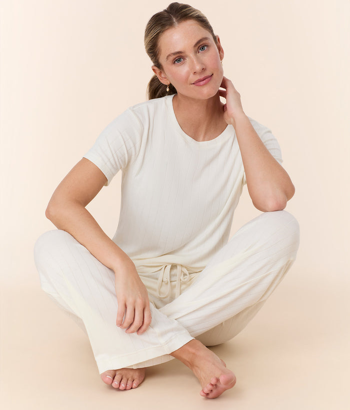 Andie Swim snow white wide leg pant with adjustable elastic waistband, high-rise fit, and relaxed silhouette on model.